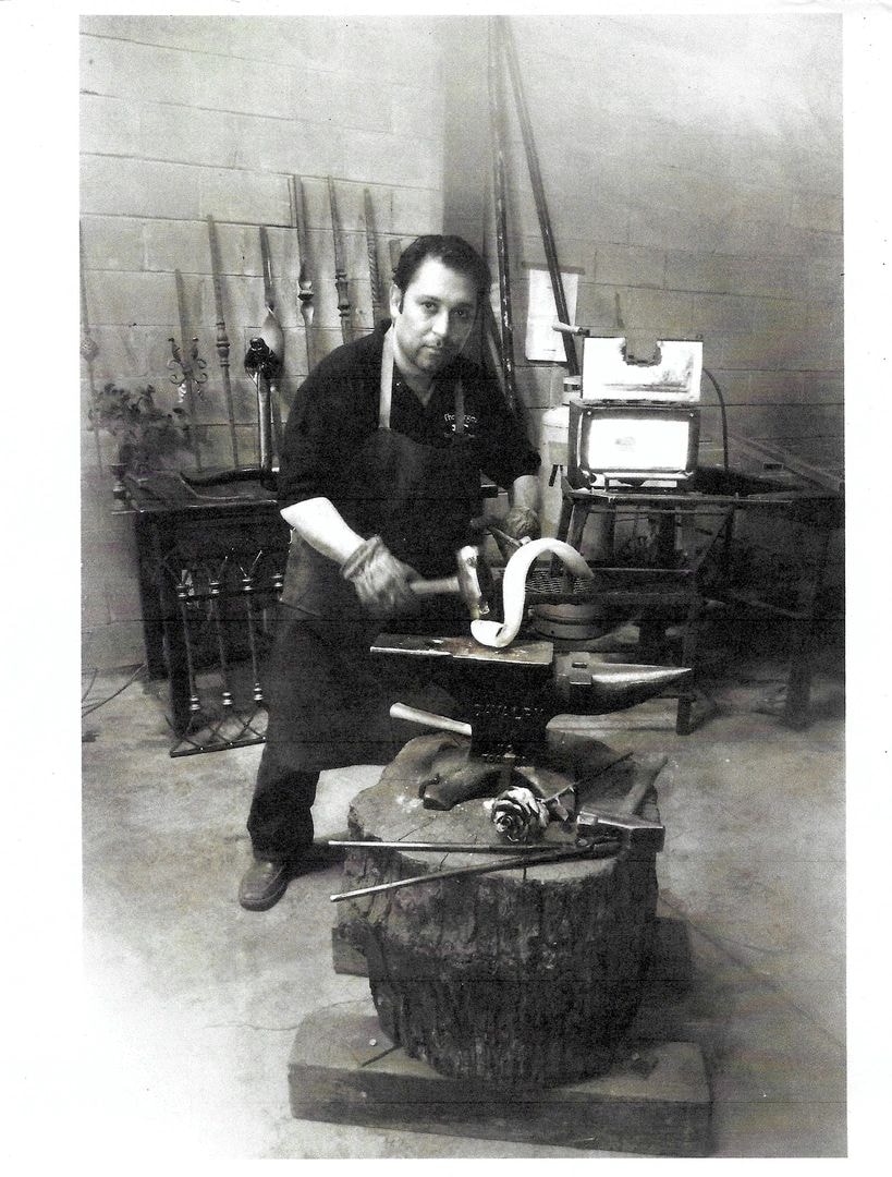 Blacksmith working metal at an anvil in a workshop